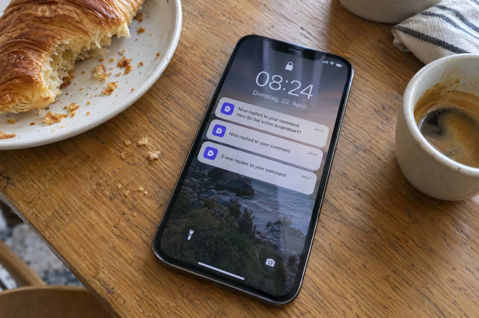Smartphone på et køkkenbord med push-notifikationer om, at et brand har svaret på ens egen kommentar